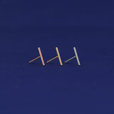 Three versions of the Tall Line Earring shown in options of rose, yellow, and white gold