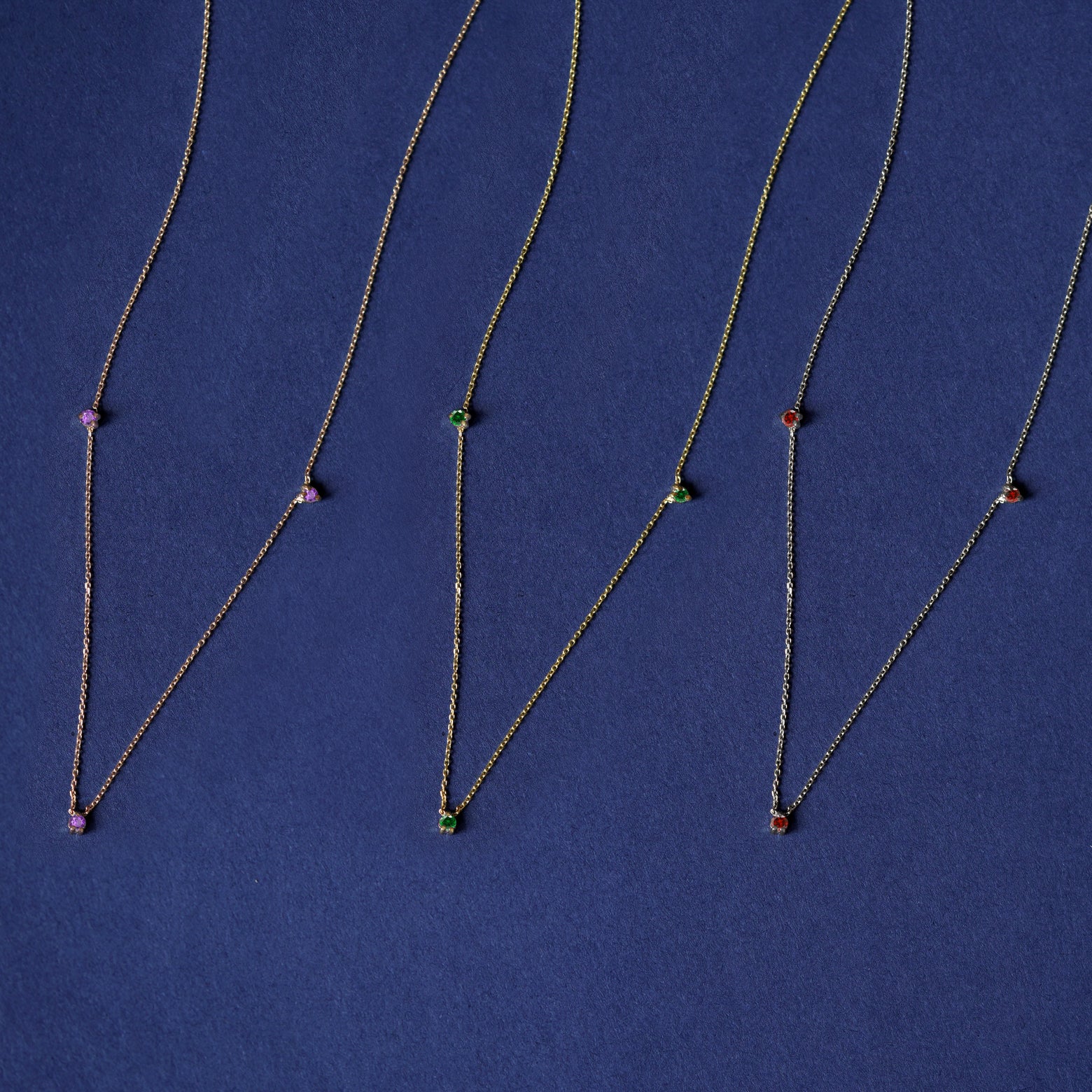 Three versions of the Three Gemstone Cable Necklaces shown in options of rose, yellow, and white gold