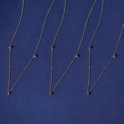 Three versions of the Three Gemstone Cable Necklaces shown in options of rose, yellow, and white gold