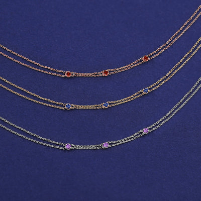 Three versions of the Three Gemstone Cable Bracelet shown in options of rose, yellow, and white gold