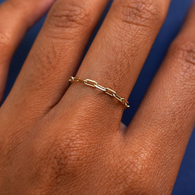 Close up view of a model's hand wearing a yellow gold Butch Chain Ring