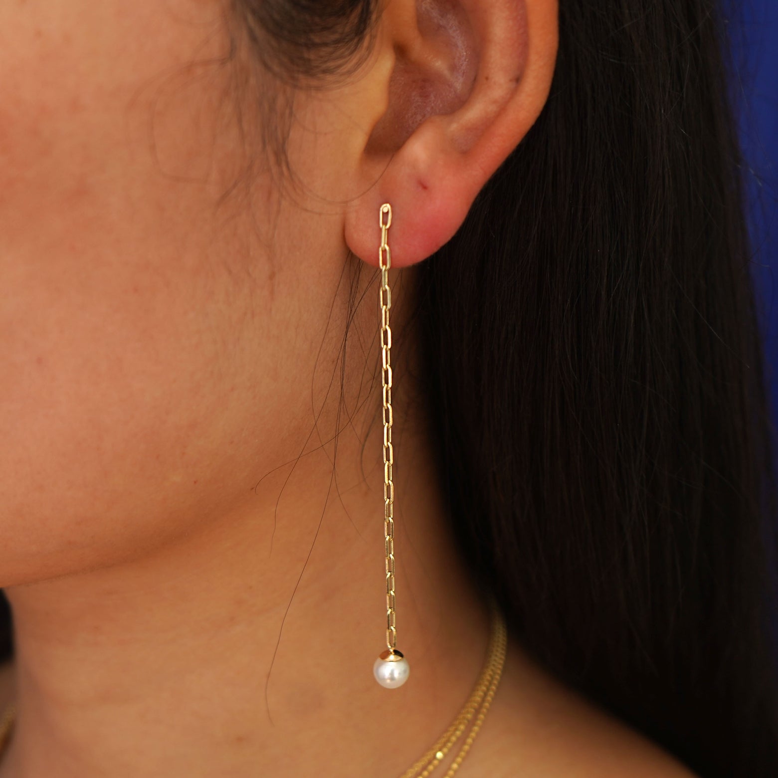 Close up view of a model's ear wearing a 14 karat yellow gold Pearl Dangle Earring