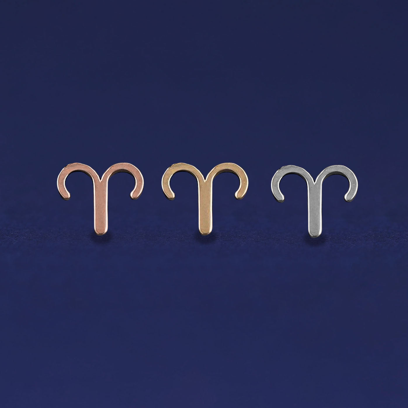 Three versions of the Aries Horoscope Earring shown in options of rose, yellow, and white gold